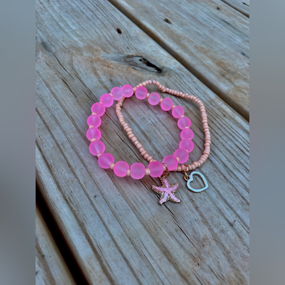 A starfish beaded bracelets, both with charms.Same Size and peachy/pink color